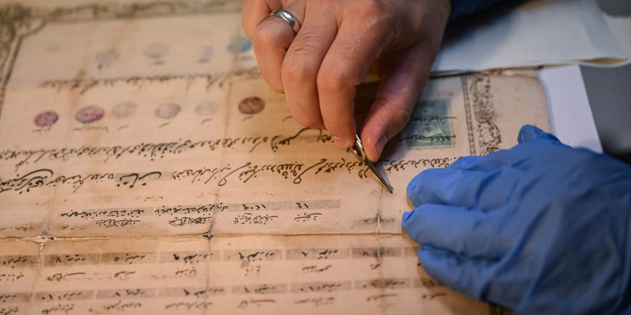 Atölyesinde eski belge ve kitapları onarıp yeniliyor