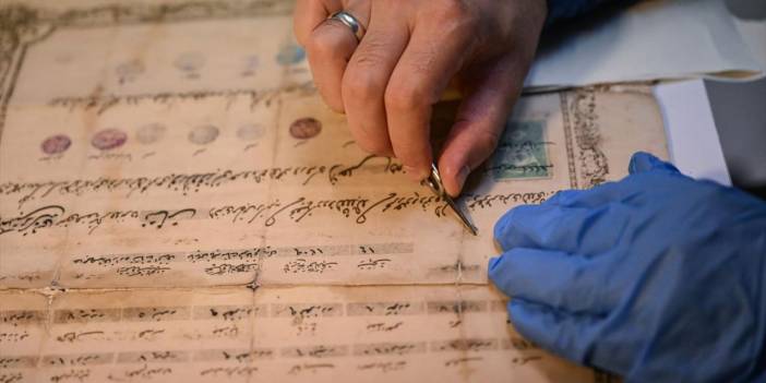 Atölyesinde eski belge ve kitapları onarıp yeniliyor