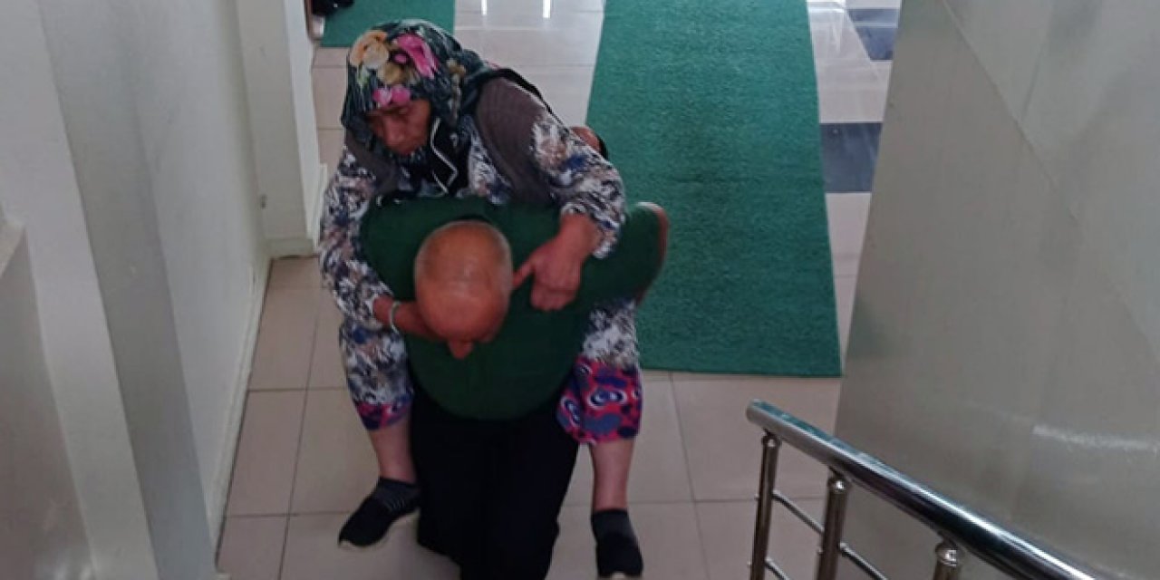 Nüfus müdürlüğü memuru, yaşlı kadını müdürlük ofisine sırtında taşıdı